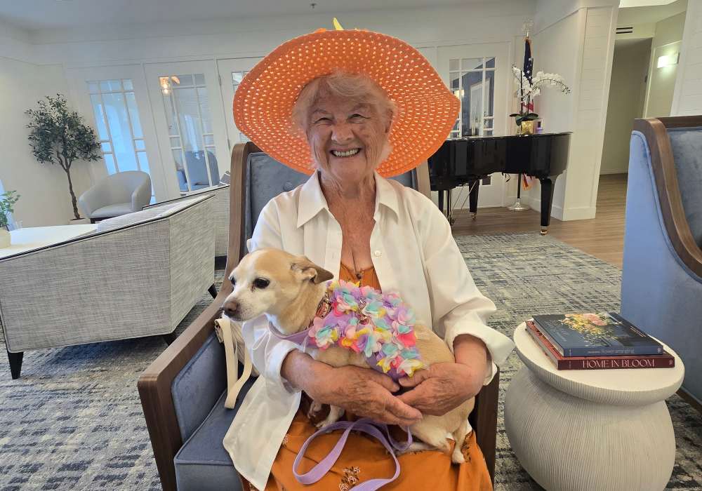 Resident holding a small dog in a common area