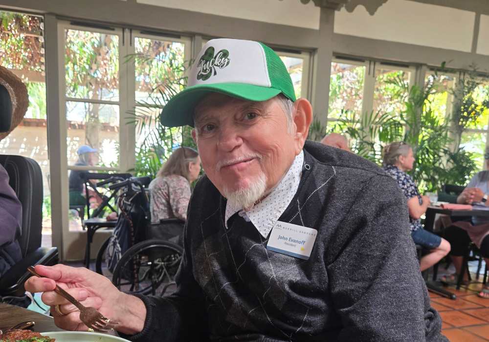 A smiling resident enjoying a meal in the dining area