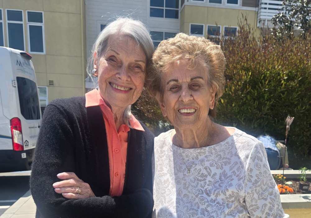 Two smiling residents posing outdoors