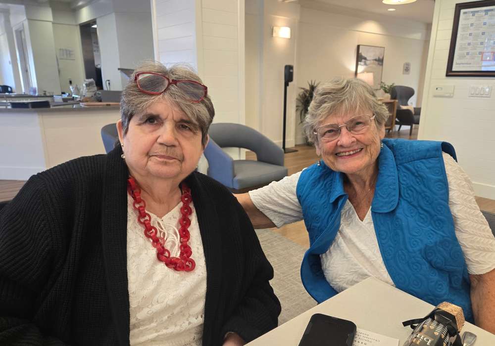 Two cheerful residents sitting together at a common table