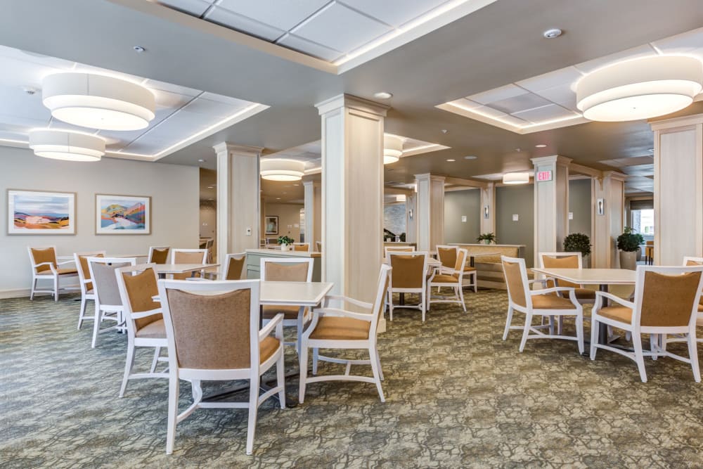 Bright common area with dining tables in an assisted living facility
