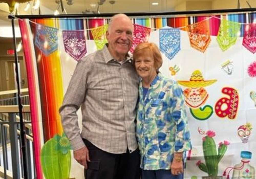 Residents celebrating in front of a colorful backdrop