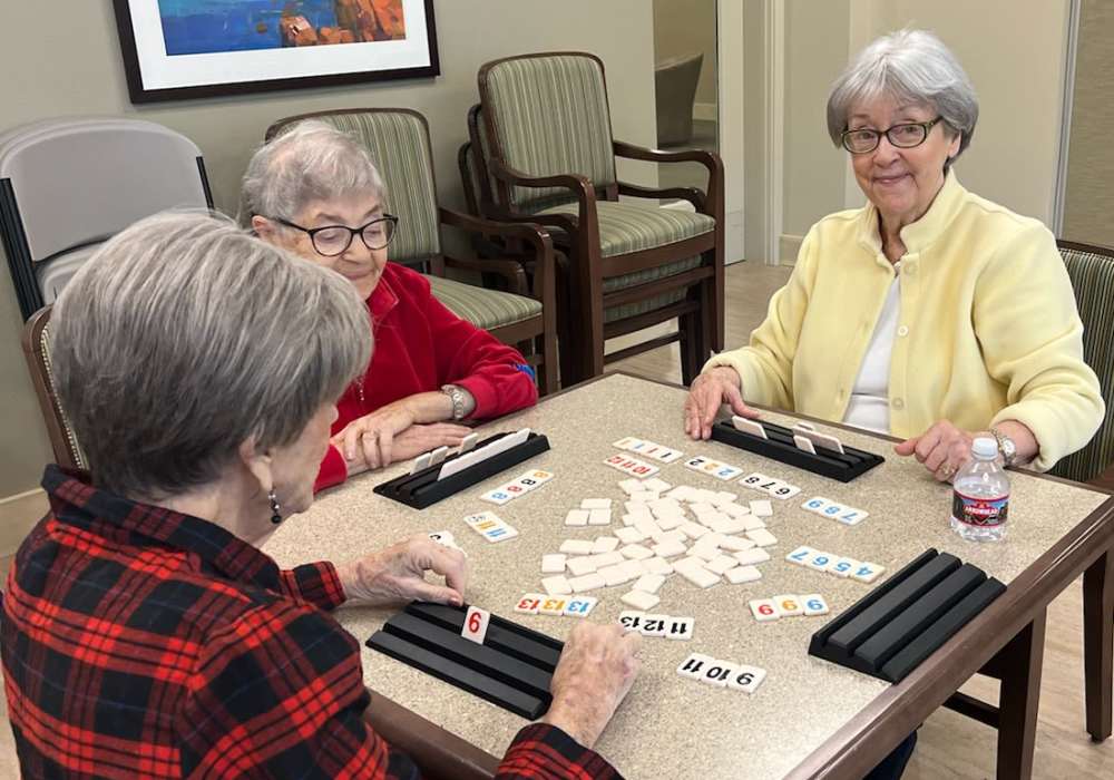 Three residents playing a game in a common area