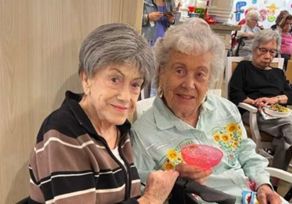 Two residents enjoying a colorful drink in a common area