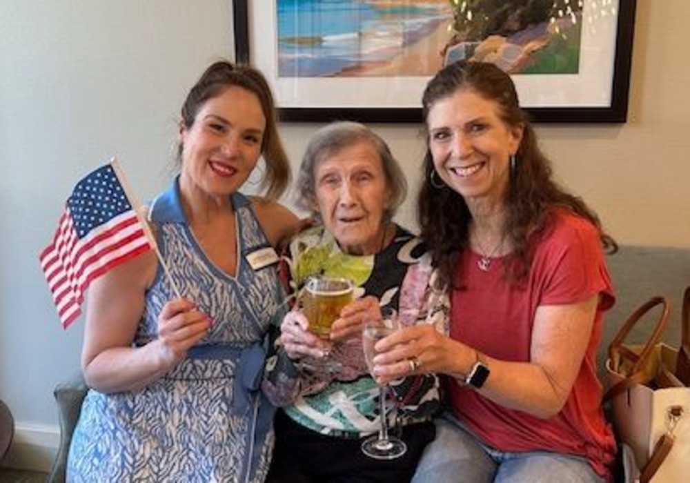 Residents and staff celebrating with drinks and an American flag