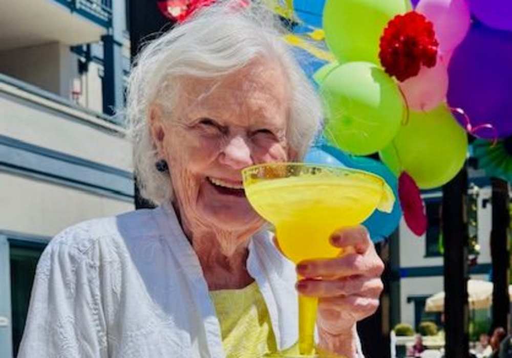 Resident enjoying a yellow drink at an outdoor event