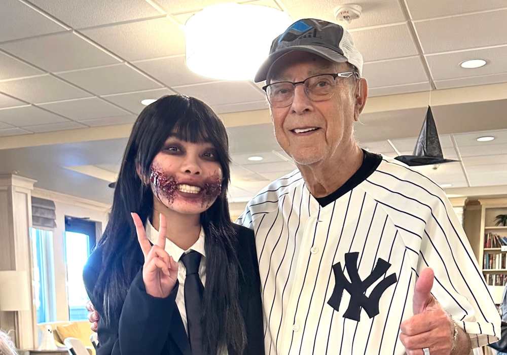 Resident posing with staff member in a themed outfit
