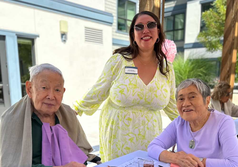 Elderly residents and staff member at an outdoor event
