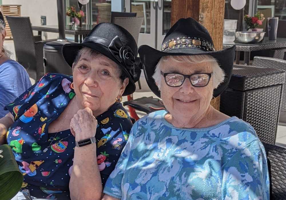 Two residents enjoying their time outdoors in stylish hats
