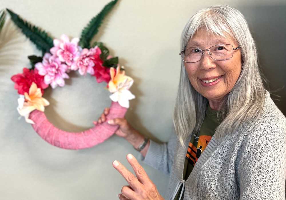 Resident posing with a decorative wreath in the facility