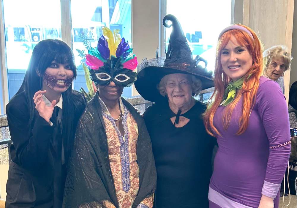 Residents and staff dressed in costumes at a Halloween celebration
