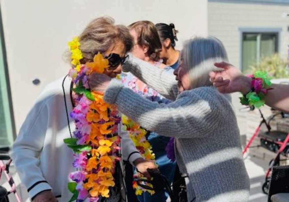 Residents celebrating with flower leis at a community event