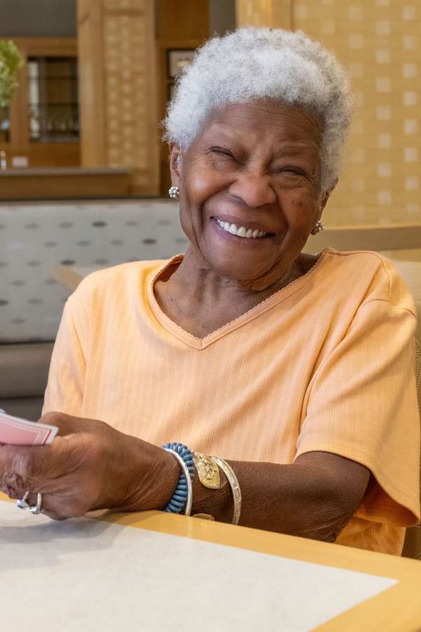 Smiling resident playing cards in a common area