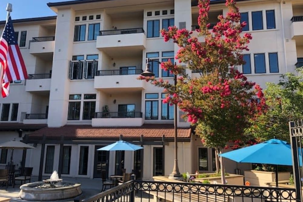 Exterior view of a senior living facility with flowering trees