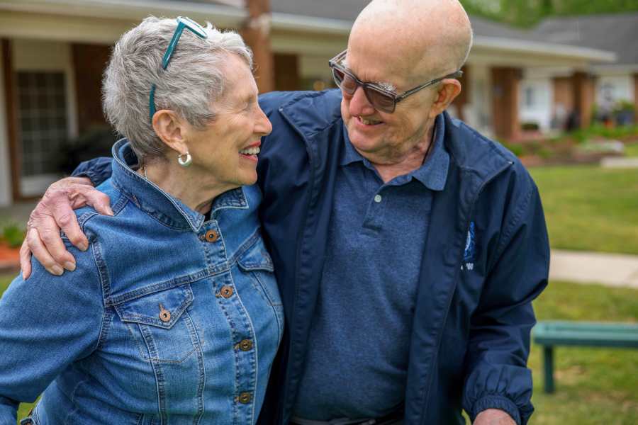 Two seniors smiling and enjoying each other's company outdoors