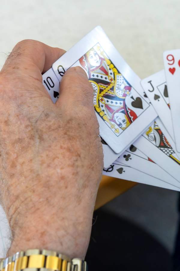 A hand holding playing cards in a game setting