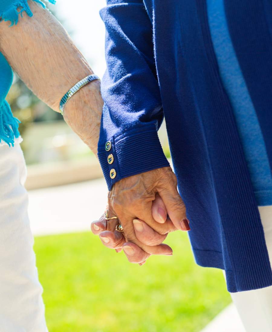 Two residents holding hands in an outdoor space
