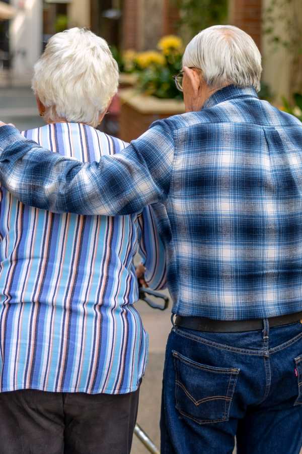 Two residents walking together in a sunny pathway