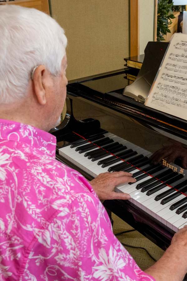 Resident playing piano in a common area