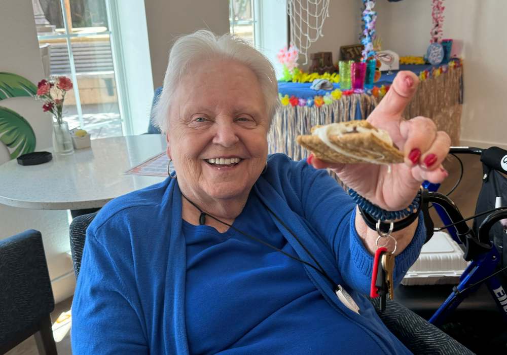 Resident enjoying a homemade treat and smiling