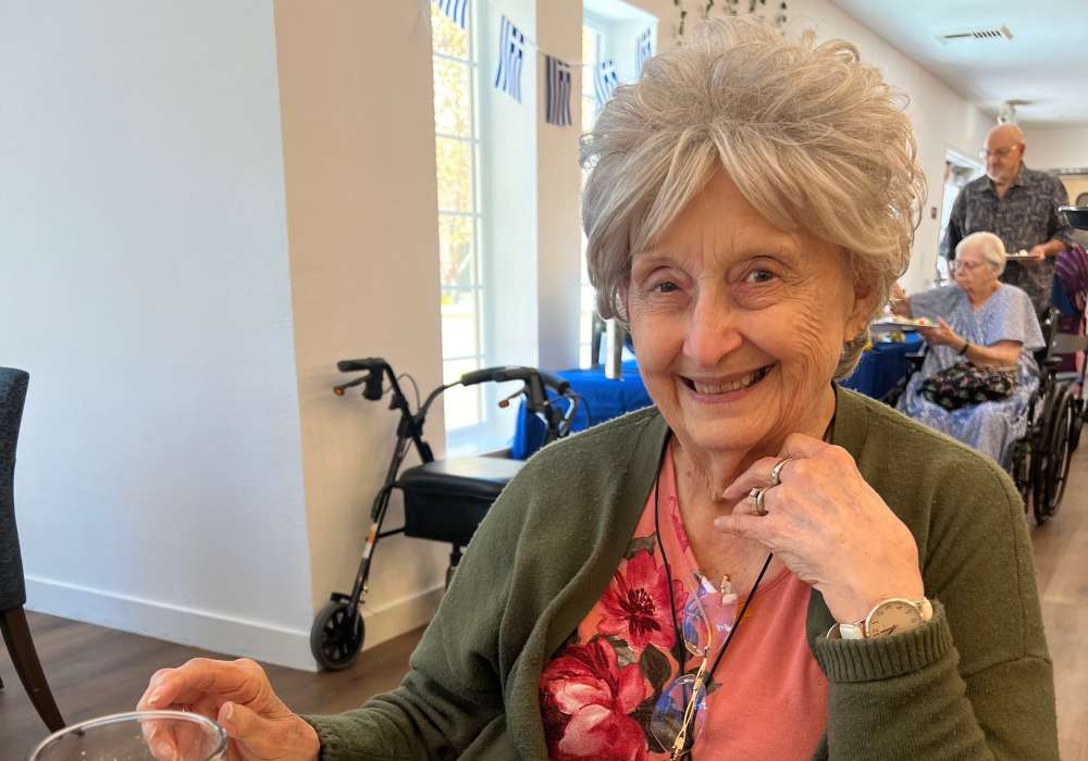 A smiling resident enjoying company in a bright common area