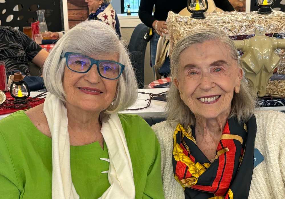 Two smiling female residents in the dining area