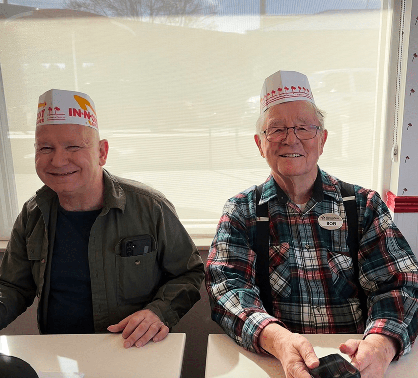 Two residents in paper hats enjoying their time