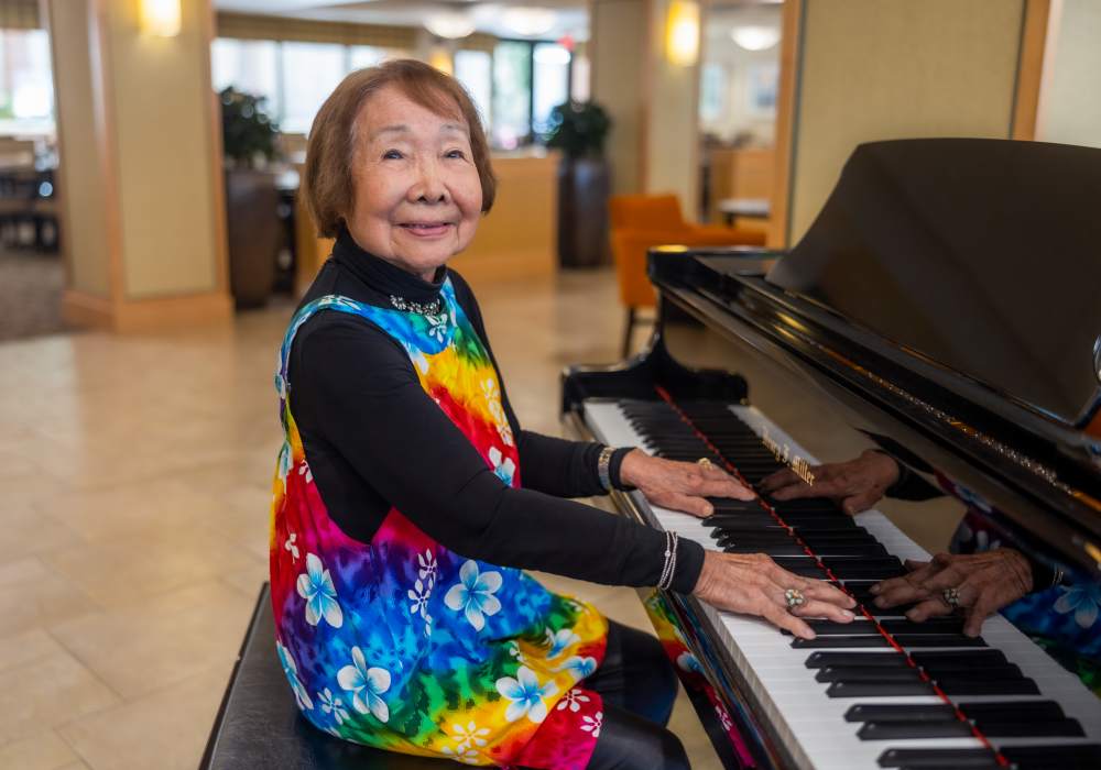 Resident playing piano in a colorful outfit