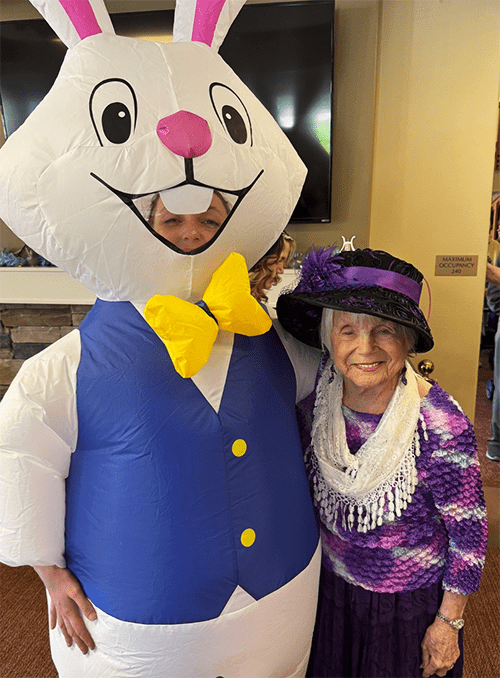 Resident posing with a costumed character in the facility