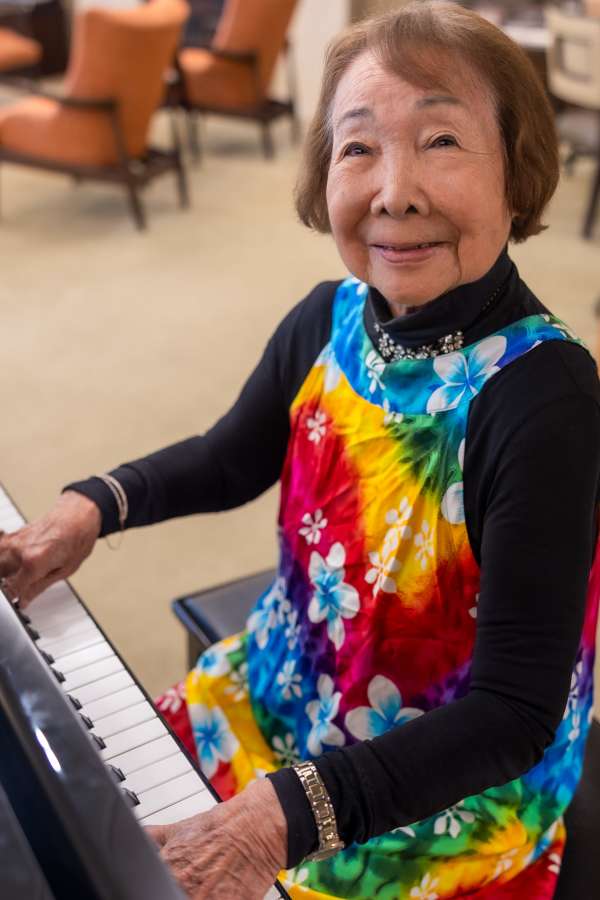 Resident playing piano in a vibrant outfit