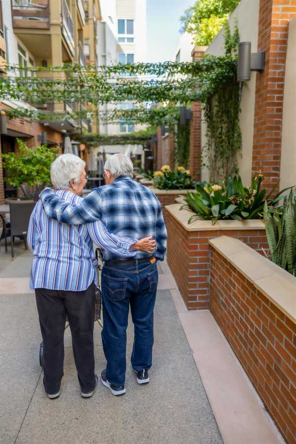 Two residents walking in a lush outdoor area