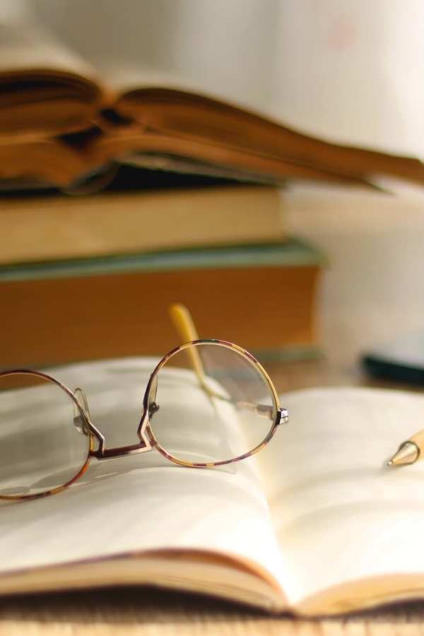 A pair of reading glasses on an open book