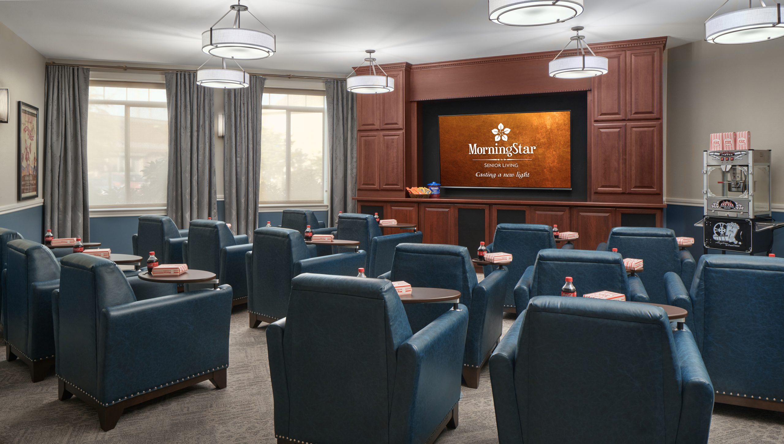 A common area with blue chairs and a presentation screen