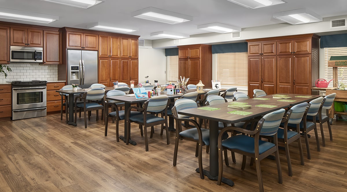 Bright, welcoming activity room with tables and chairs