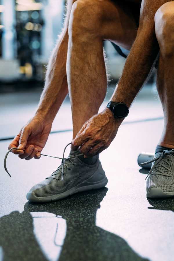 Close-up of an elderly man tying his shoelaces
