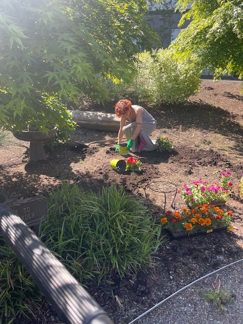 A resident gardening in a vibrant outdoor space
