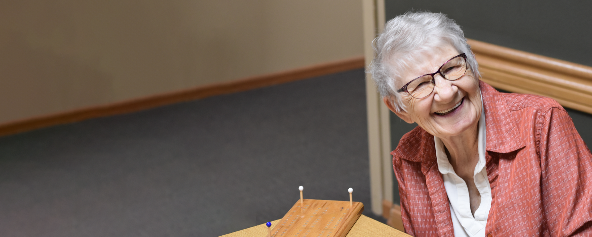A smiling senior woman engaging in an activity.
