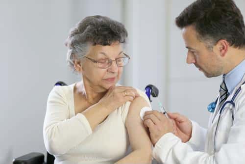 Doctor administering a vaccine to a senior resident