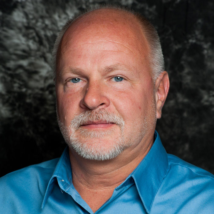A man with short gray hair and a blue shirt