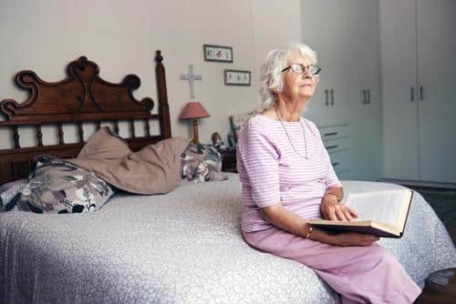 A resident reading in a cozy bedroom