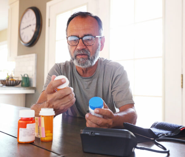 Senior man managing his medication at a table