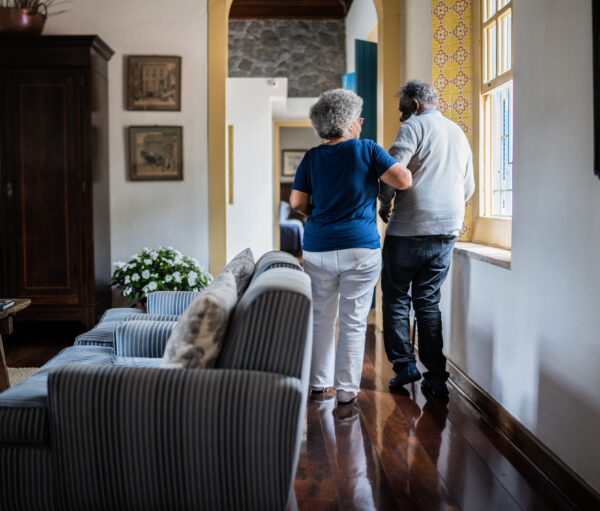 A caregiver assisting a resident in a hallway