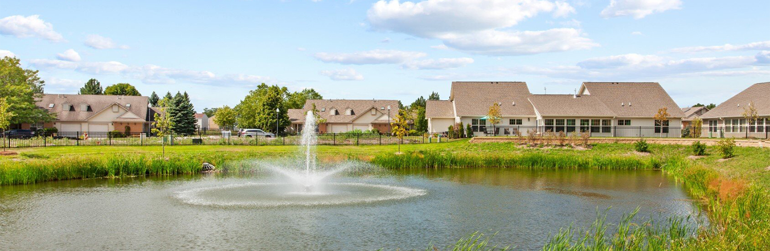 Scenic view of a pond with fountain and residential buildings
