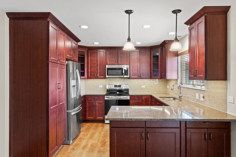 A modern kitchen interior with brown cabinets