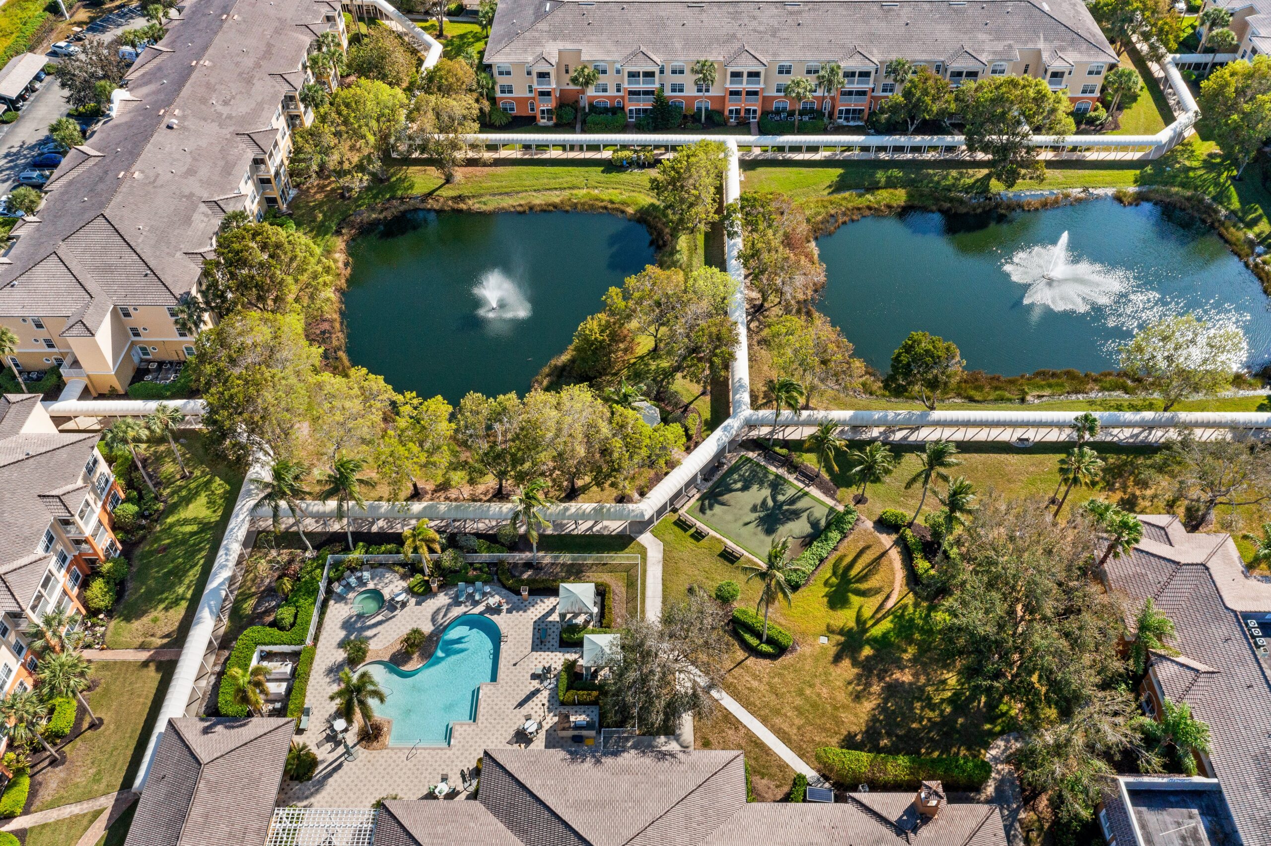 Aerial view of a senior living campus with ponds and pool