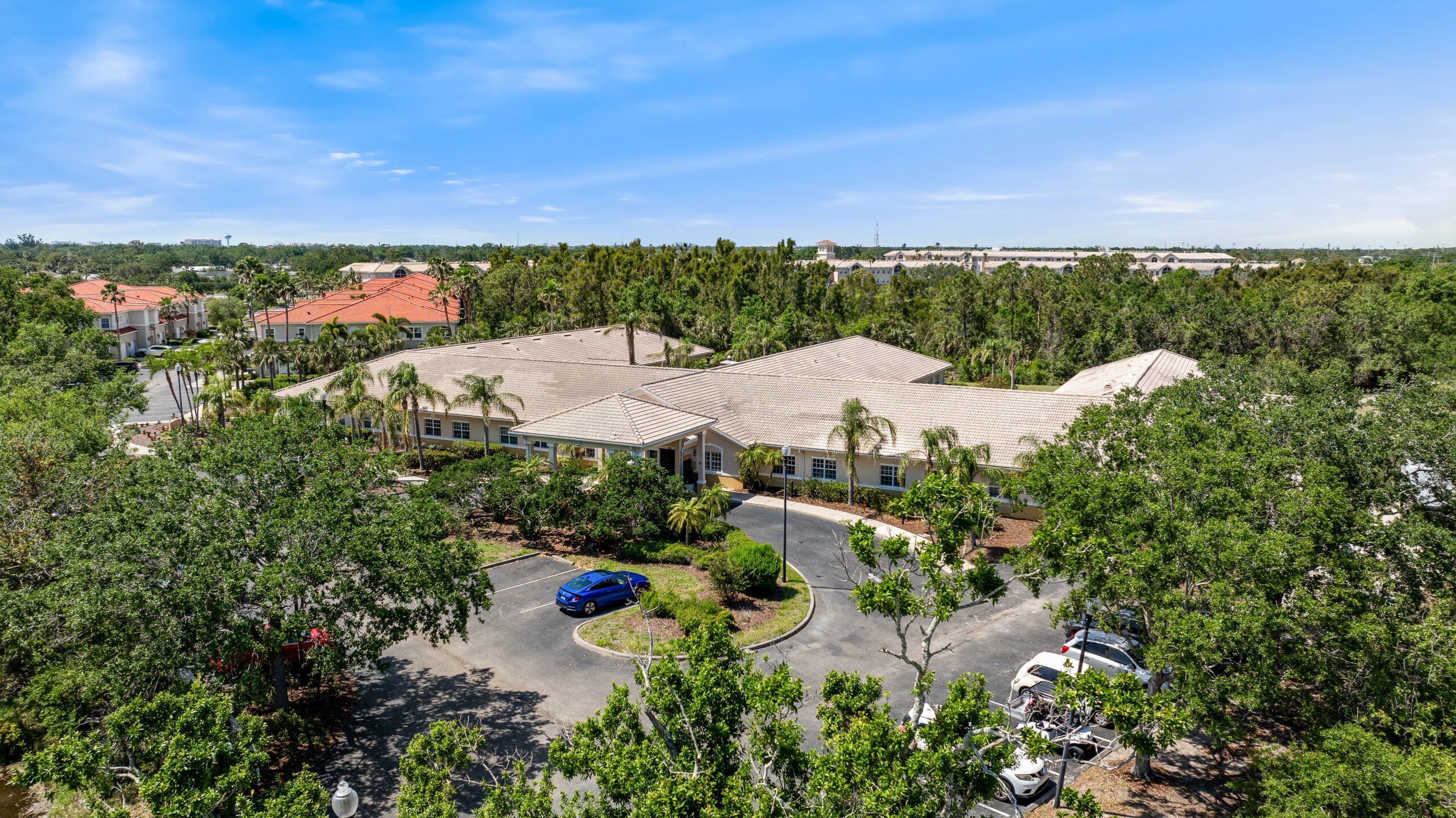 Aerial view of Aston Gardens at Pelican Pointe surrounded by greenery