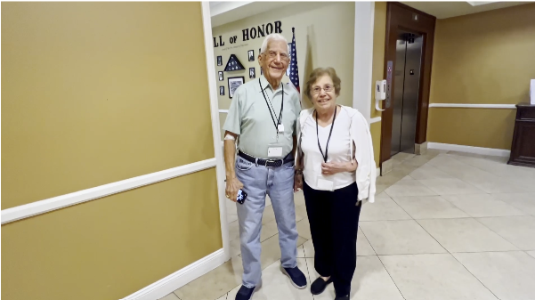 Two residents smiling in a facility hallway