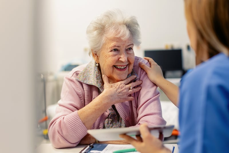 A caregiver interacting with a senior resident in a facility room
