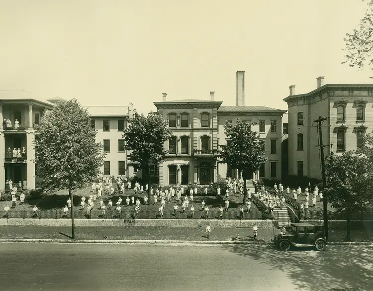 Historic view of the health center with residents in the garden