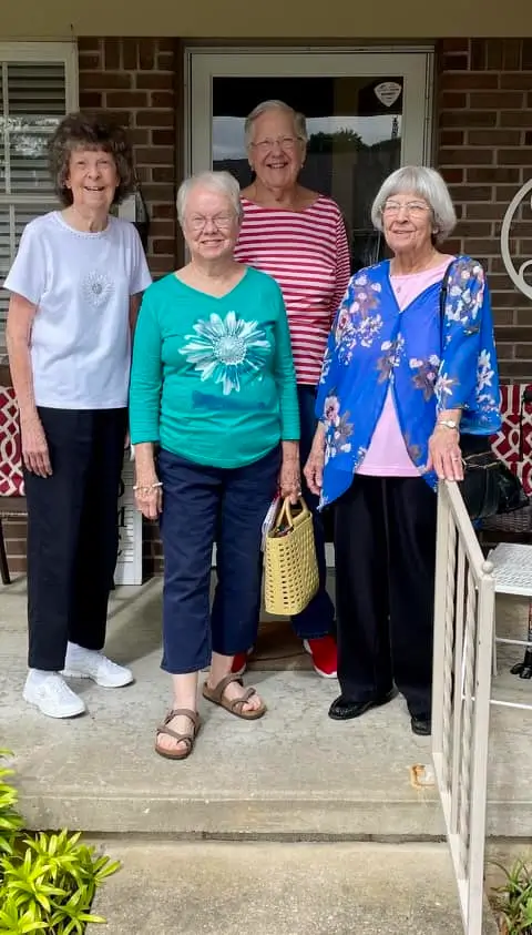 Four residents posing together at the entrance